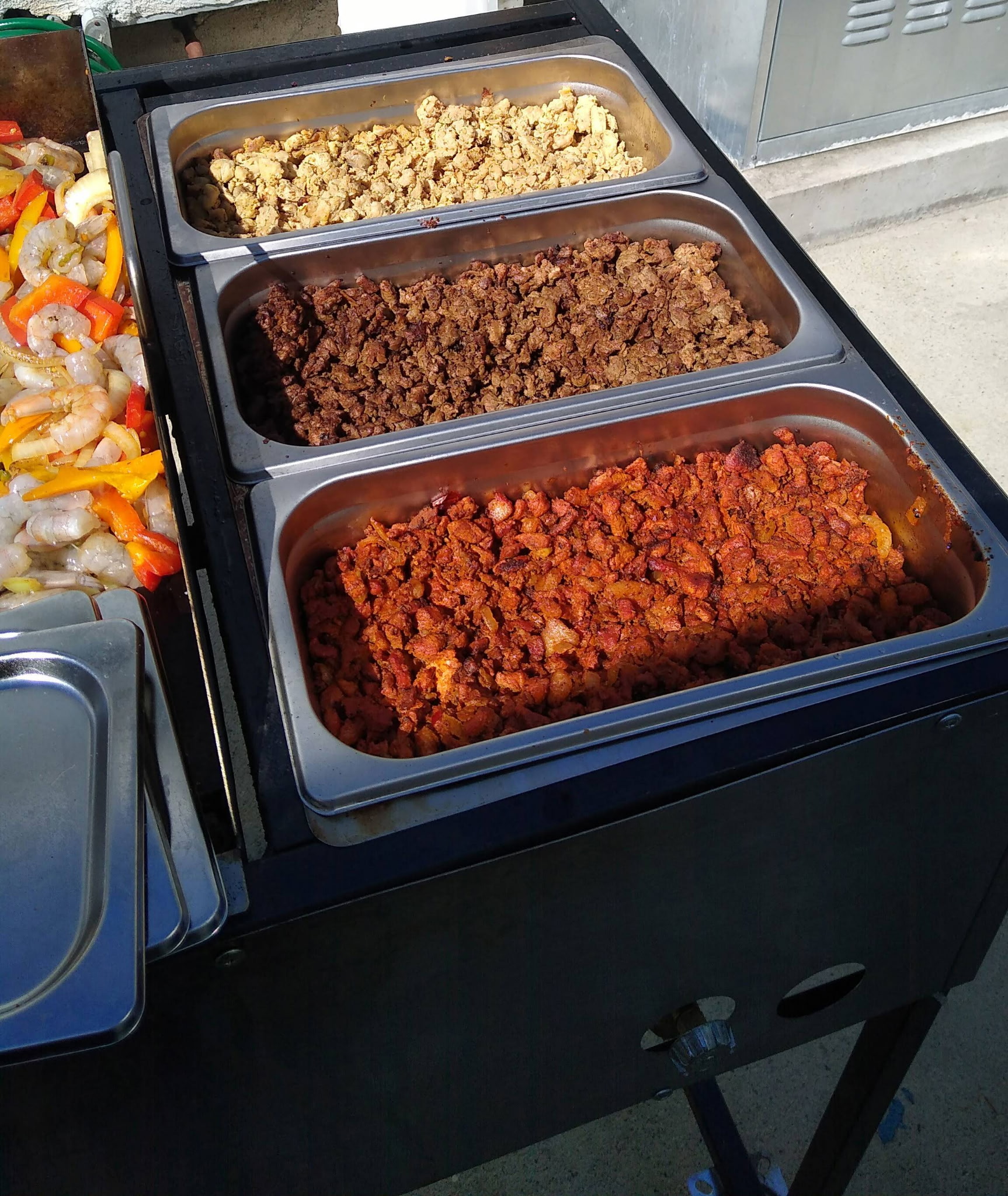Freshly prepared taco meats displayed in catering trays
