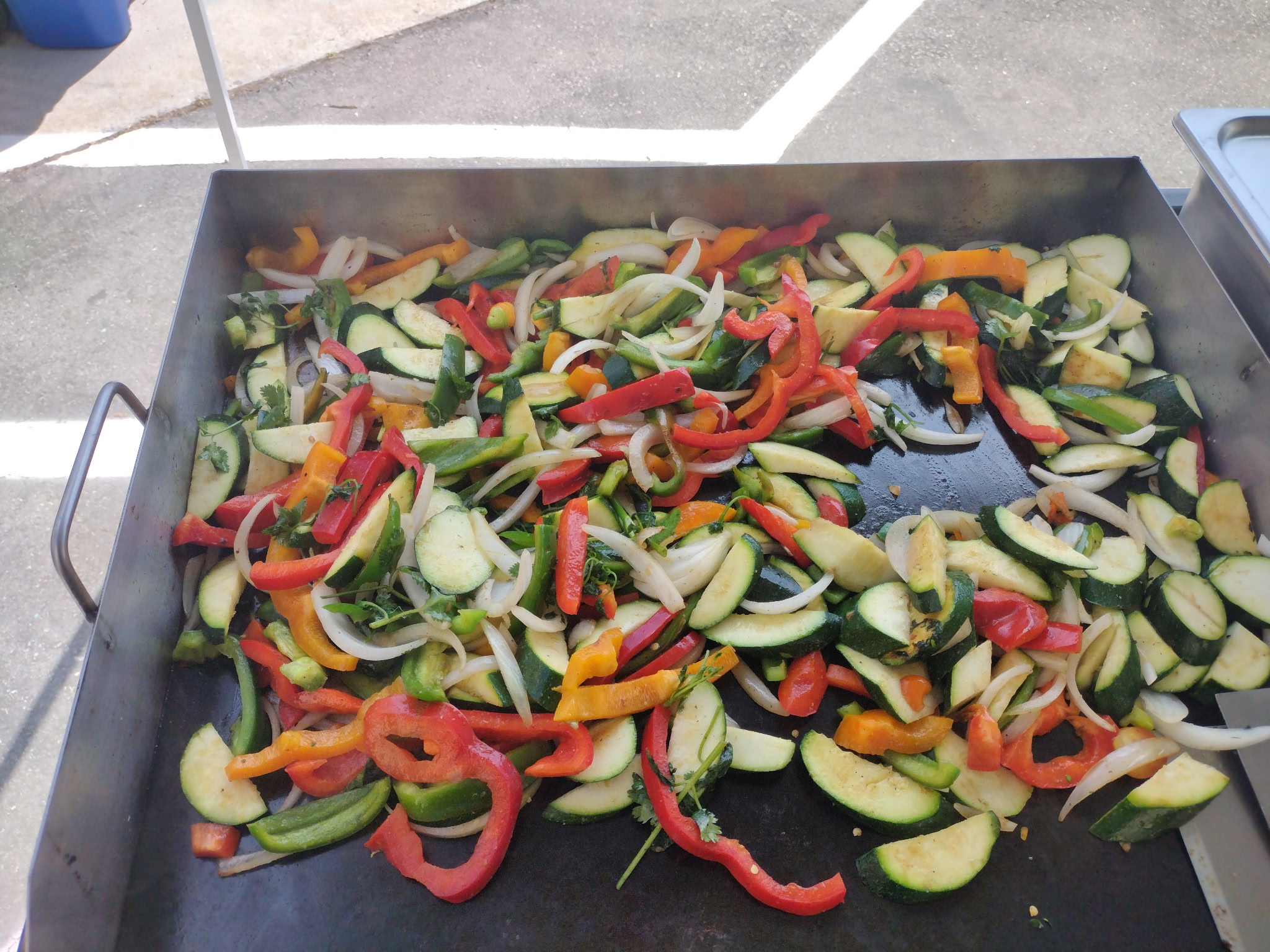 Colorful vegetables cooking on a flat-top grill